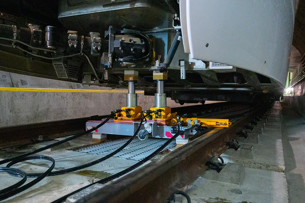 Système de relevage hydraulique avec vérins de levage positionné sous une rame de train pour la maintenance ferroviaire